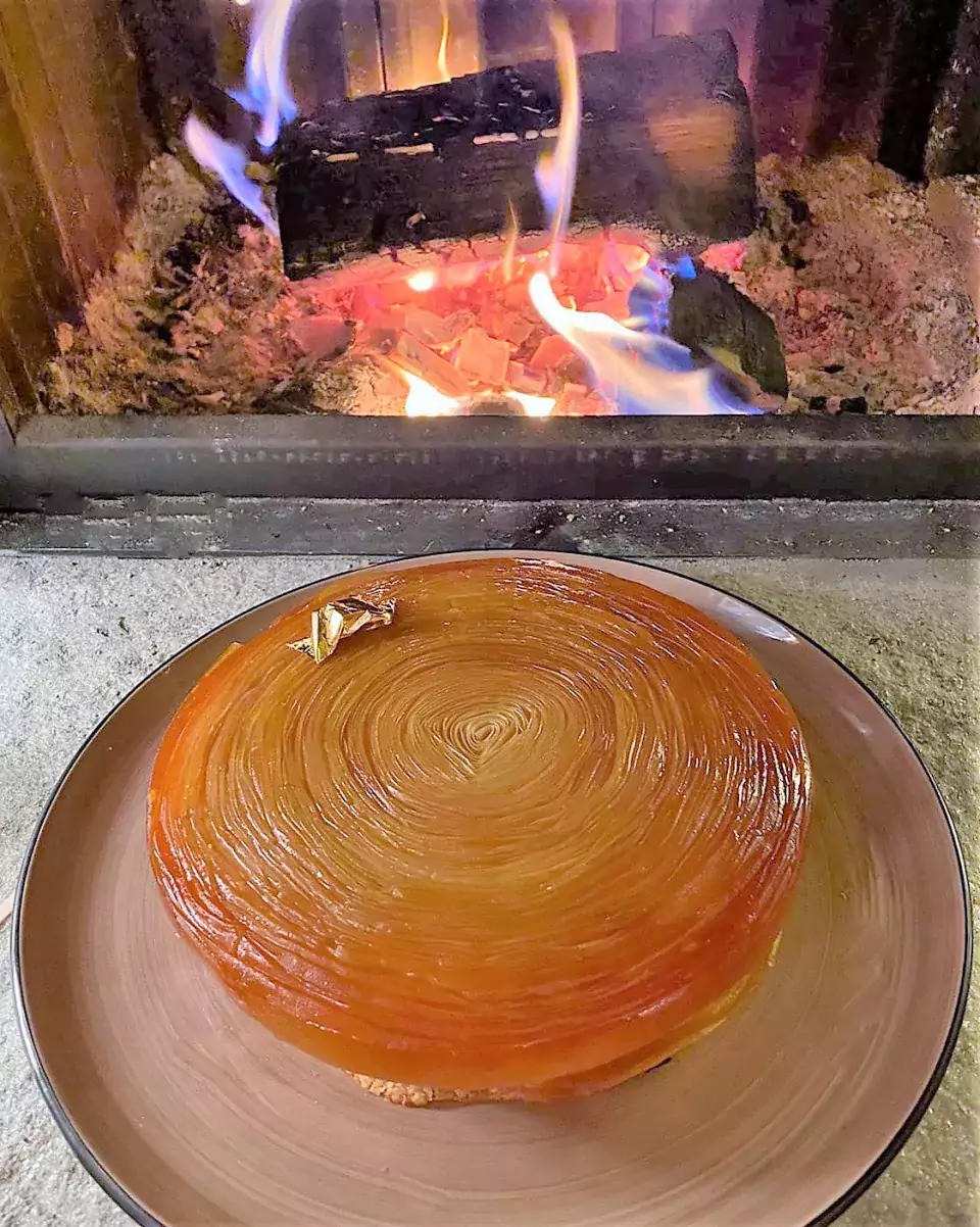 Réalisation d'une tarte tatin pour un anniversaire présentée devant feu de cheminée